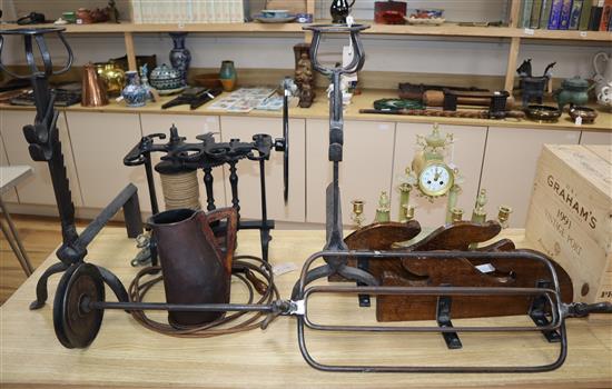 A wrought iron spit, an oak whip rack and a pair of andirons and a leather jug